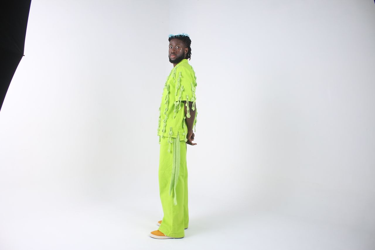 about-us A striking fashion portrait of a man in lime green attire against a white backdrop.